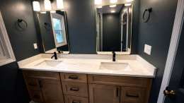 Modern primary bathroom renovation in West Michigan — frameless glass shower, double vanity, and large-format tile. Modern primary bathroom renovation in West Michigan — frameless glass shower, double vanity, and large-format tile.